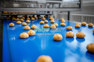 Pişmiş unlu mamullerin soğutma hattına ilerlediği gıda sınıfı konveyör bant